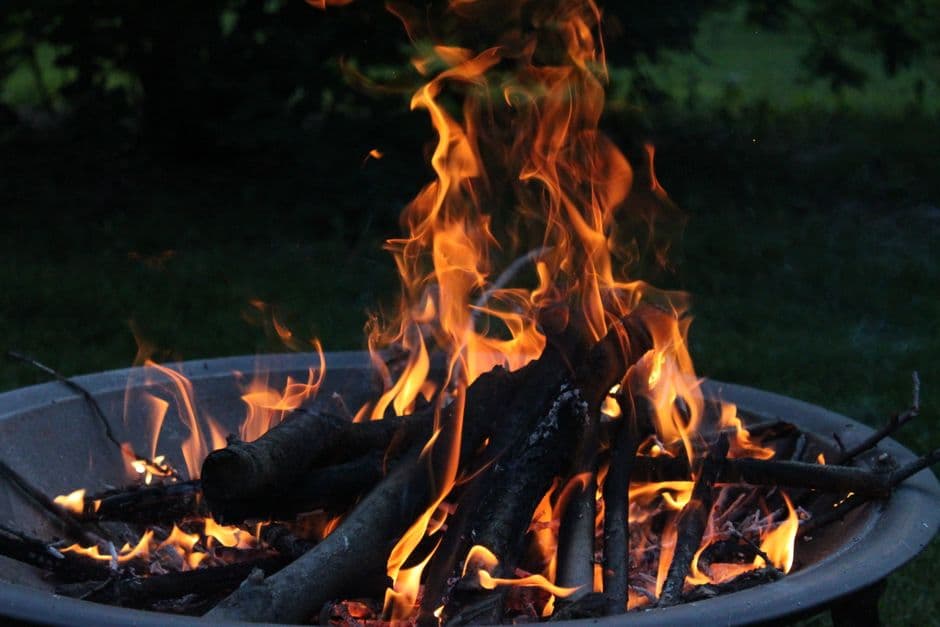 A fire burning in an outdoor fire pit after dark
