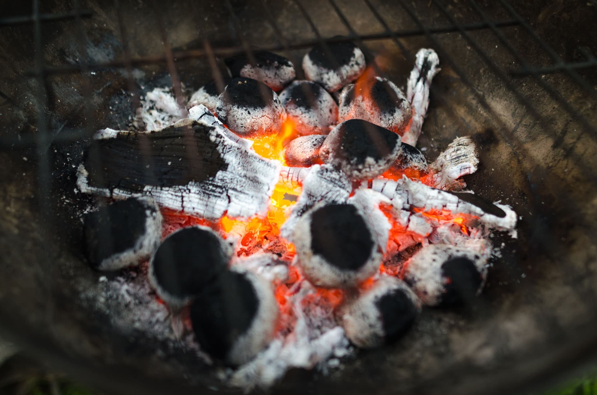 Charcoal glowing and ashing over in a grill, ready to cook