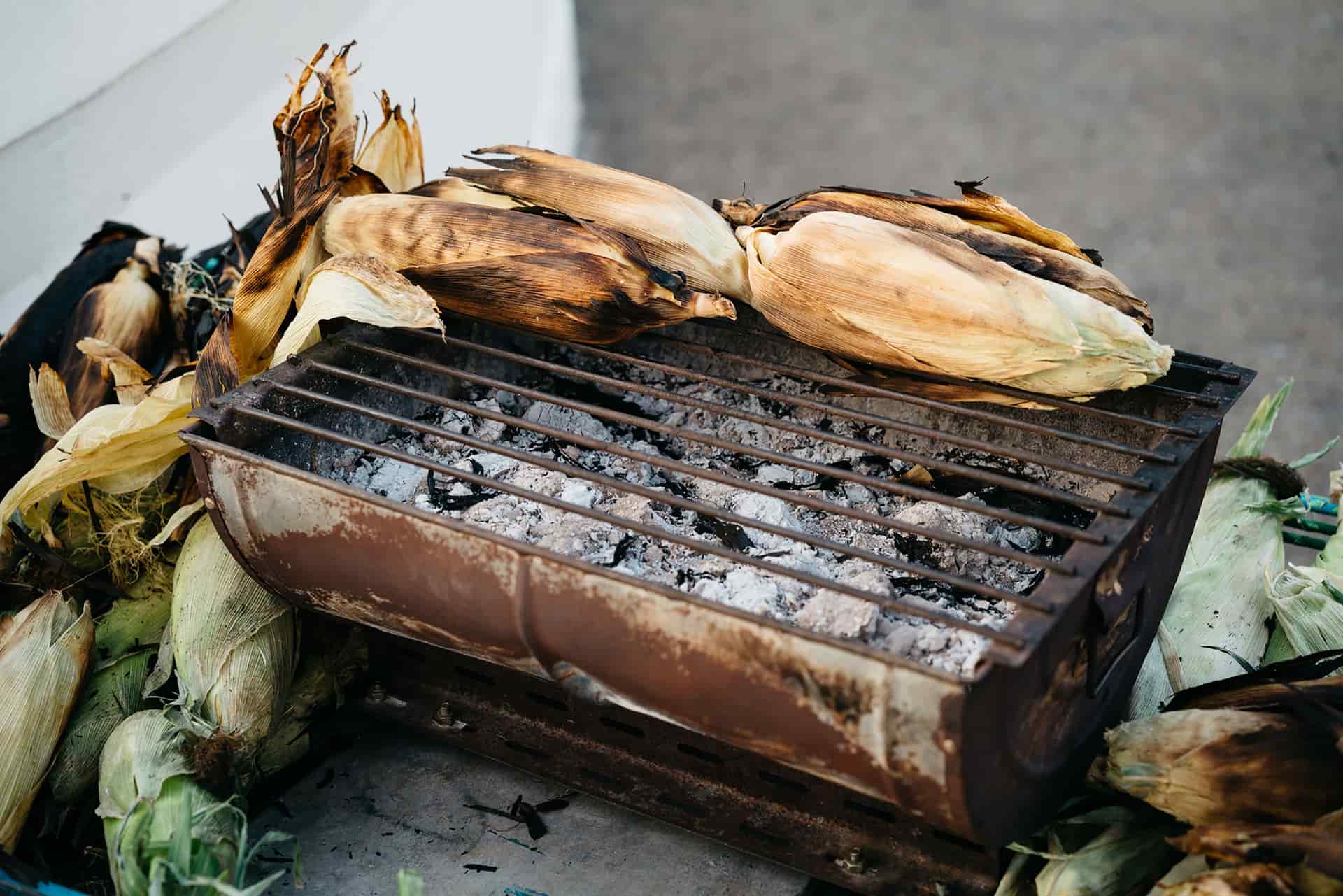 Corn on the cob charring over a charcoal grill