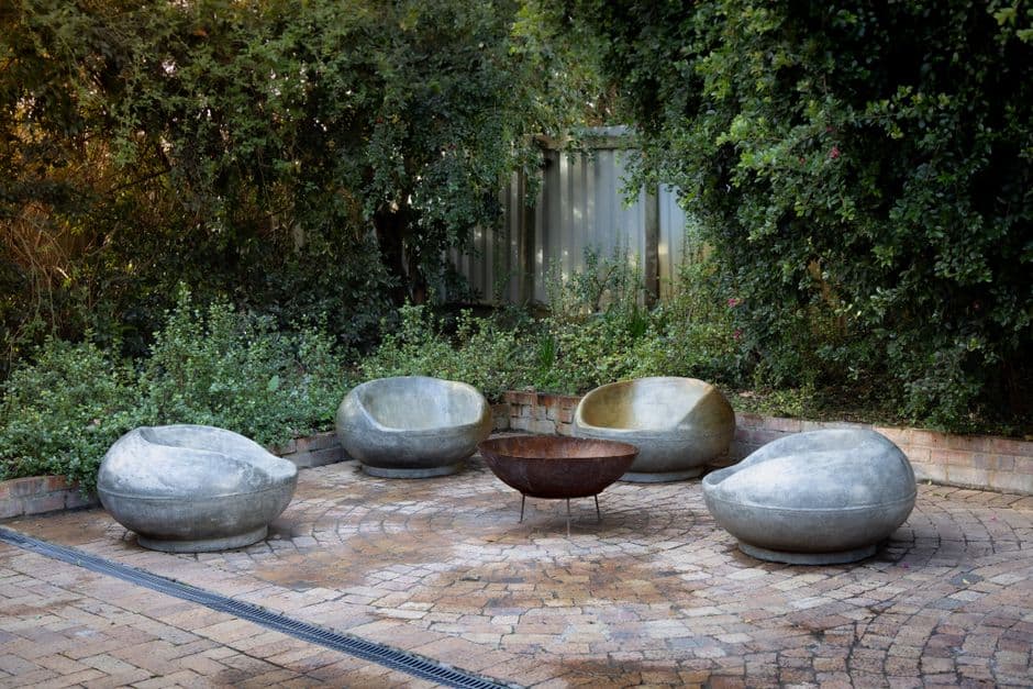 An outdoor patio with stone seating built around a fire