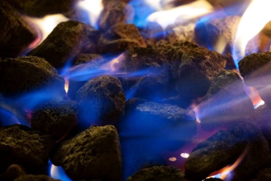 Low blue flames burning across a fire bed